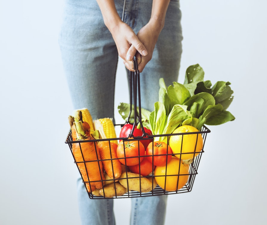 Dieticians holds nutritious foods and vegetables in a basket