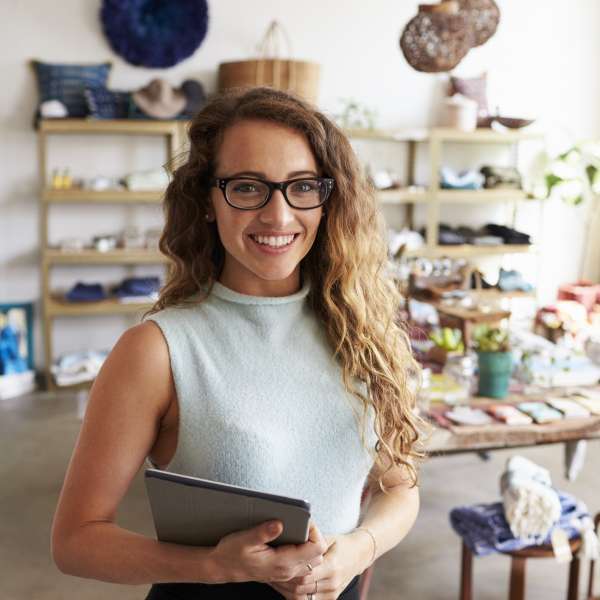 A happy small business owner holding an iPad
