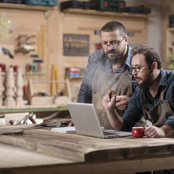 Two handymen planning a business expansion strategy on a computer