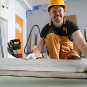 A happy carpenter works in a factory