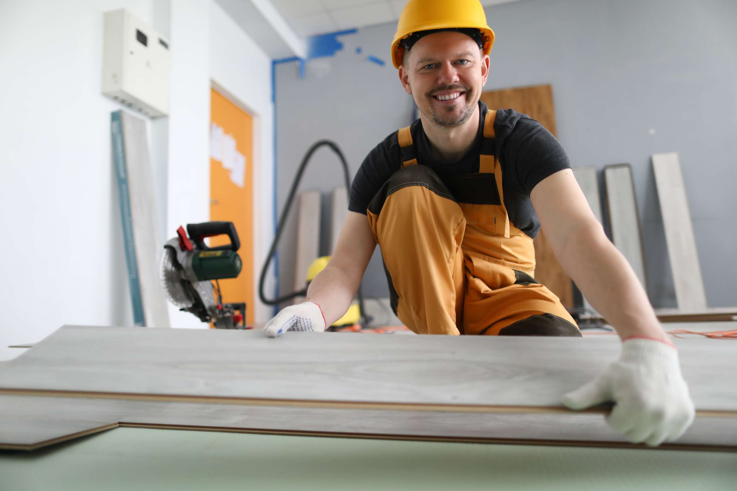 A happy carpenter works in a factory