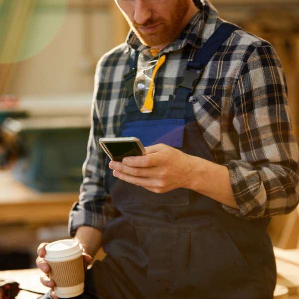 A carpenter business person with gadget at break.