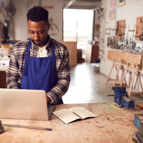 A carpenter looks on laptop