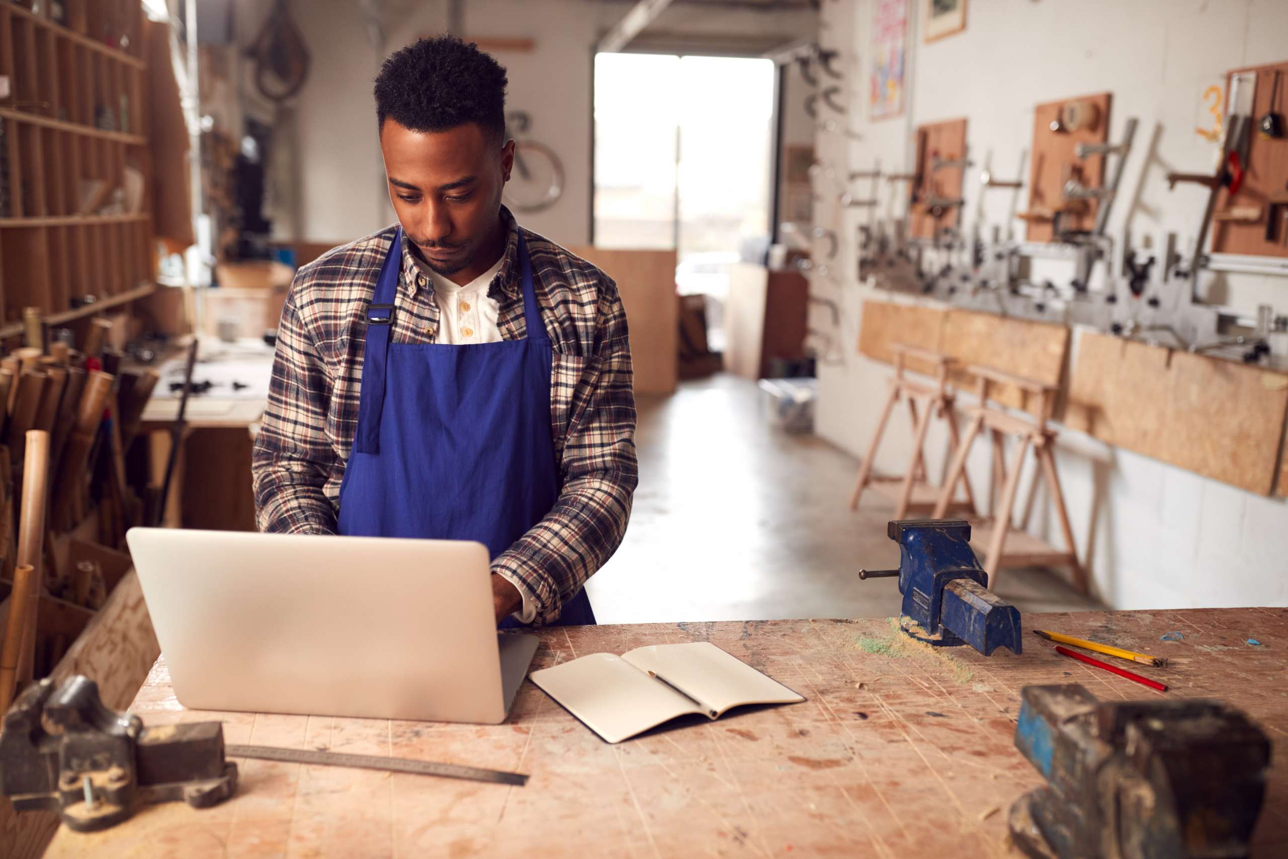 A carpenter looks on laptop