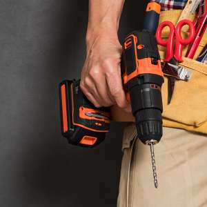 A handyman holds drill machine and othe essential tools