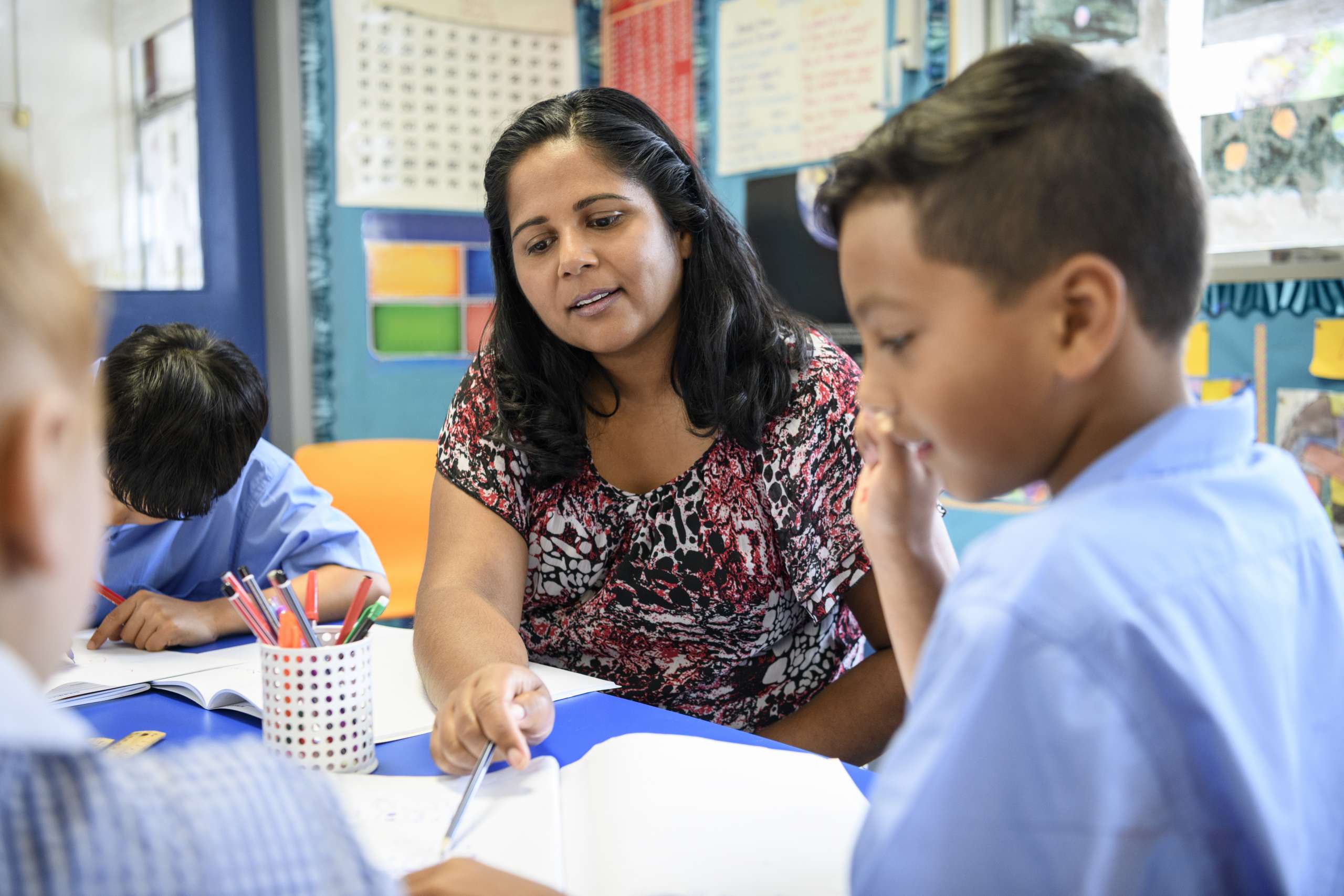 A teacher helps a student in a classroom