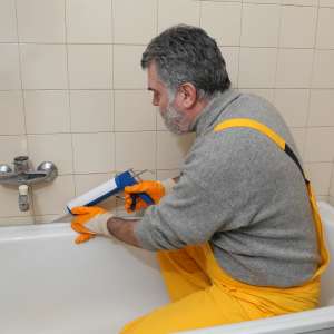 Plumber repairs bath tub and tiles