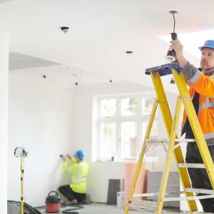 An electrician installs downlights