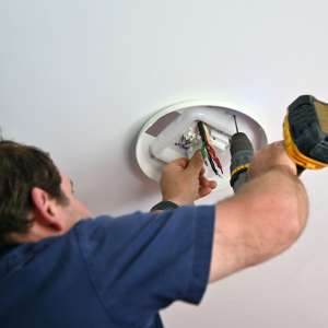 An electrician drilling on ceiling