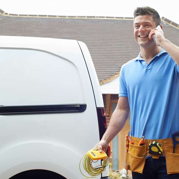 An electrician standing next to a vehicle