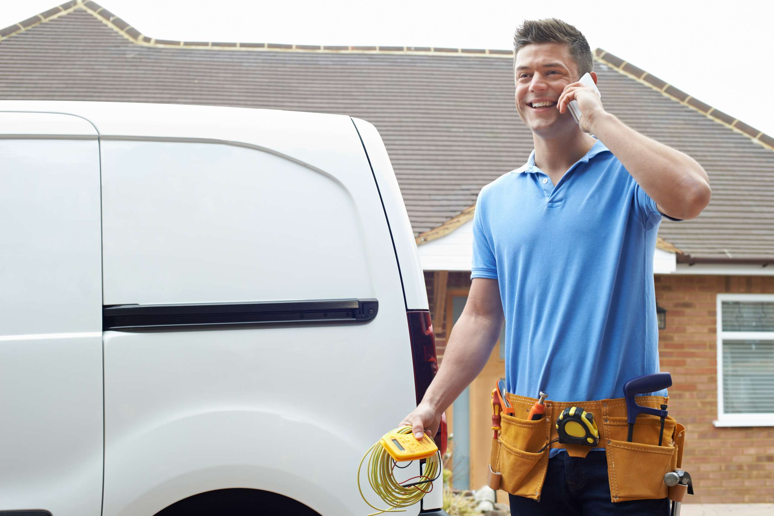 An electrician standing next to a vehicle