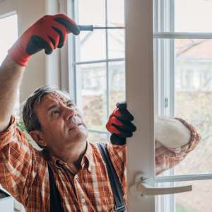 Handyman repairs a window