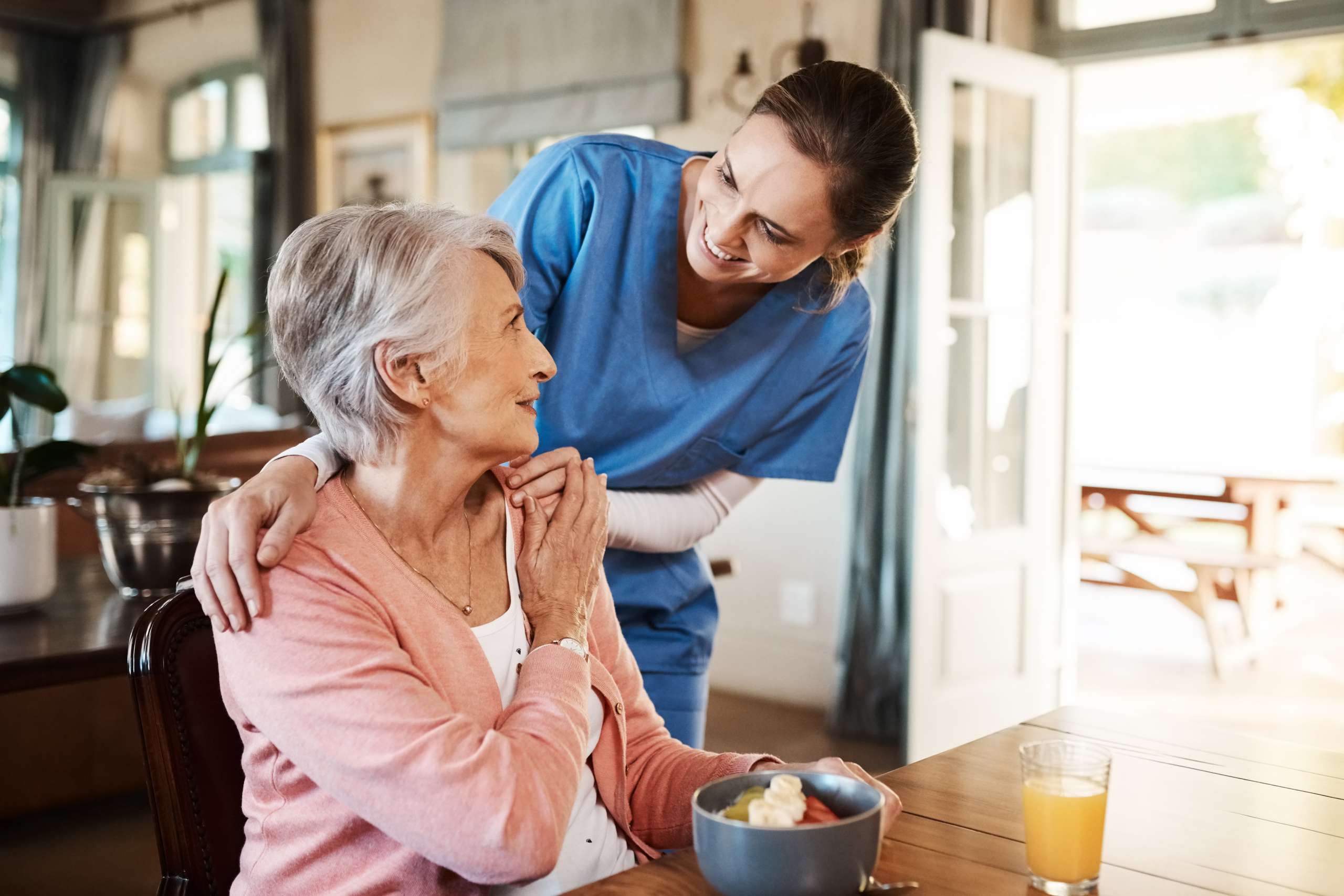 A cretaker assists a senior woman at home