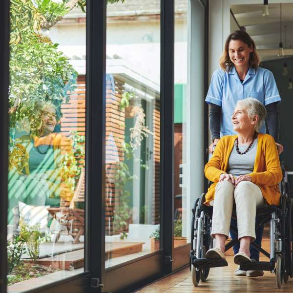 Young nurse assists a senior woman in a wheelchair