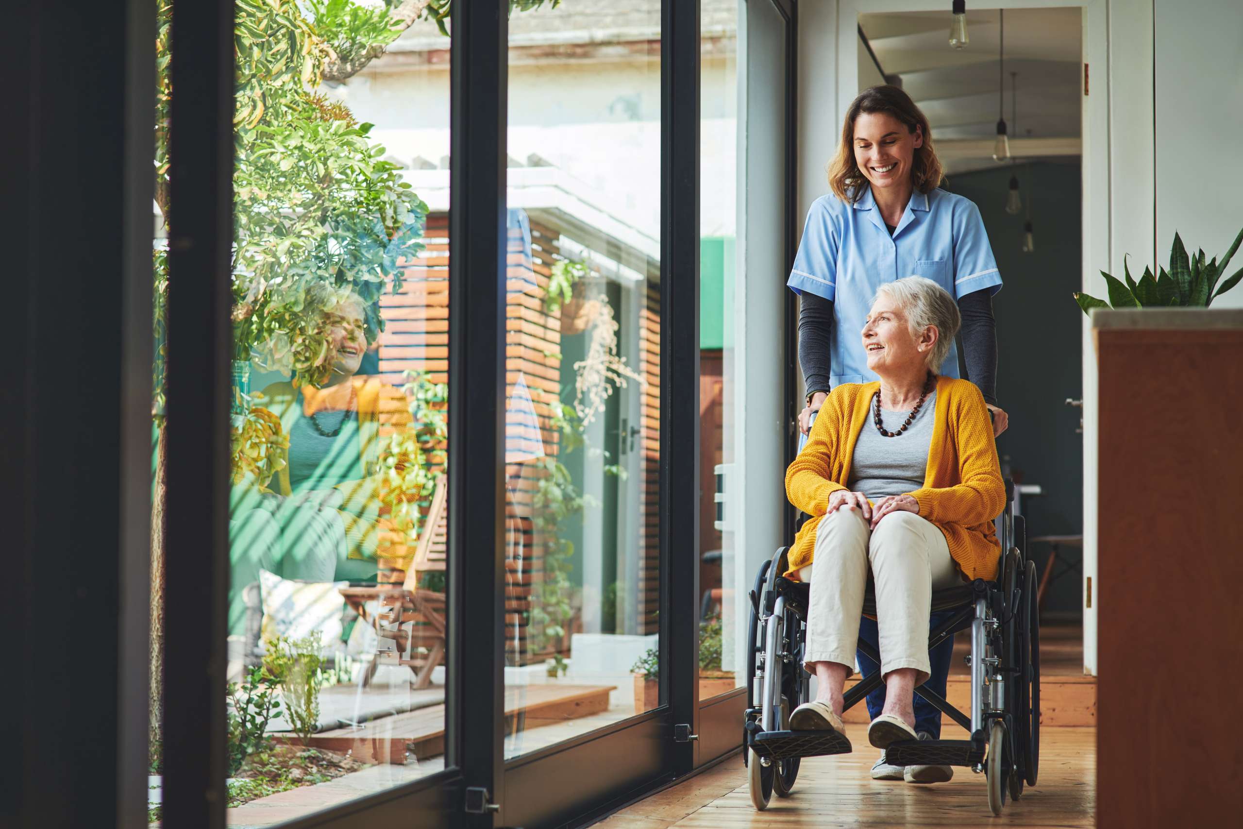 Young nurse assists a senior woman in a wheelchair