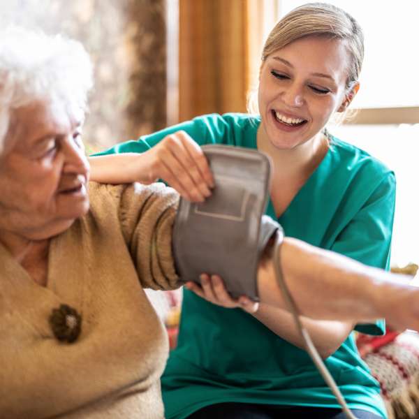 A nurse measures senior woman's blood pressure