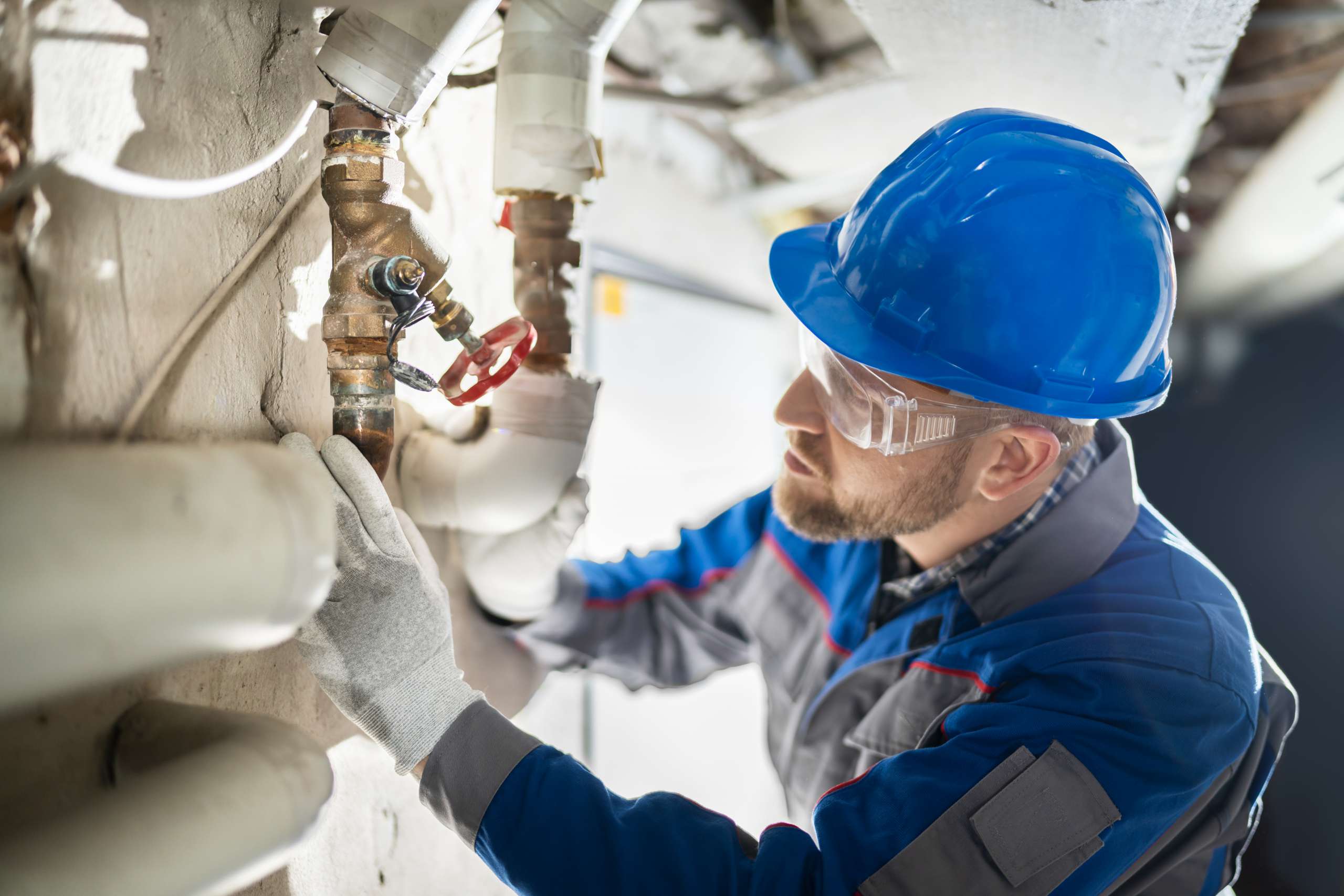 A plumber inspects water pipe valve