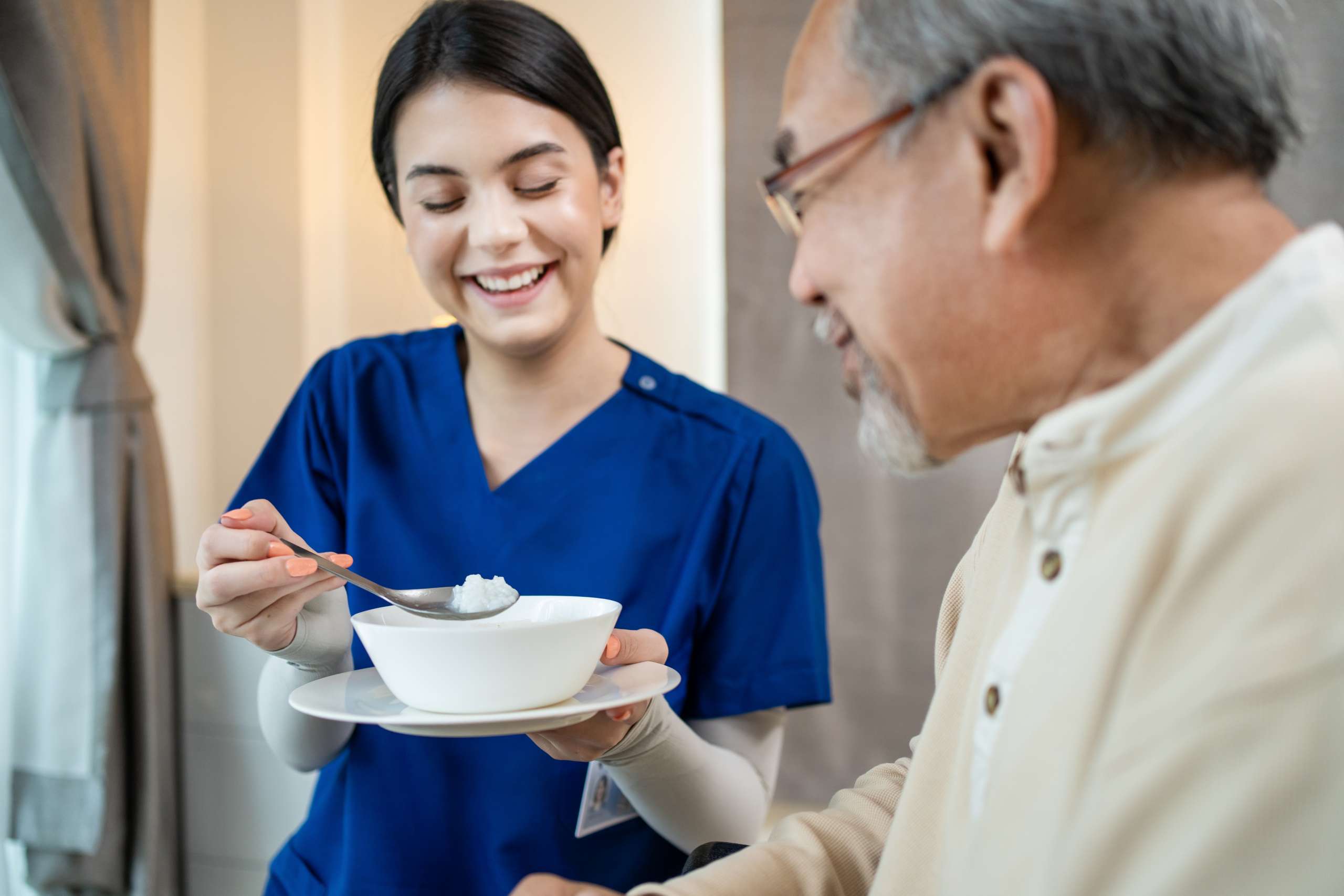 A health care worker serve food to senior patient