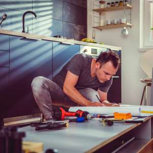 A contractor worker checks kitchen cabinet