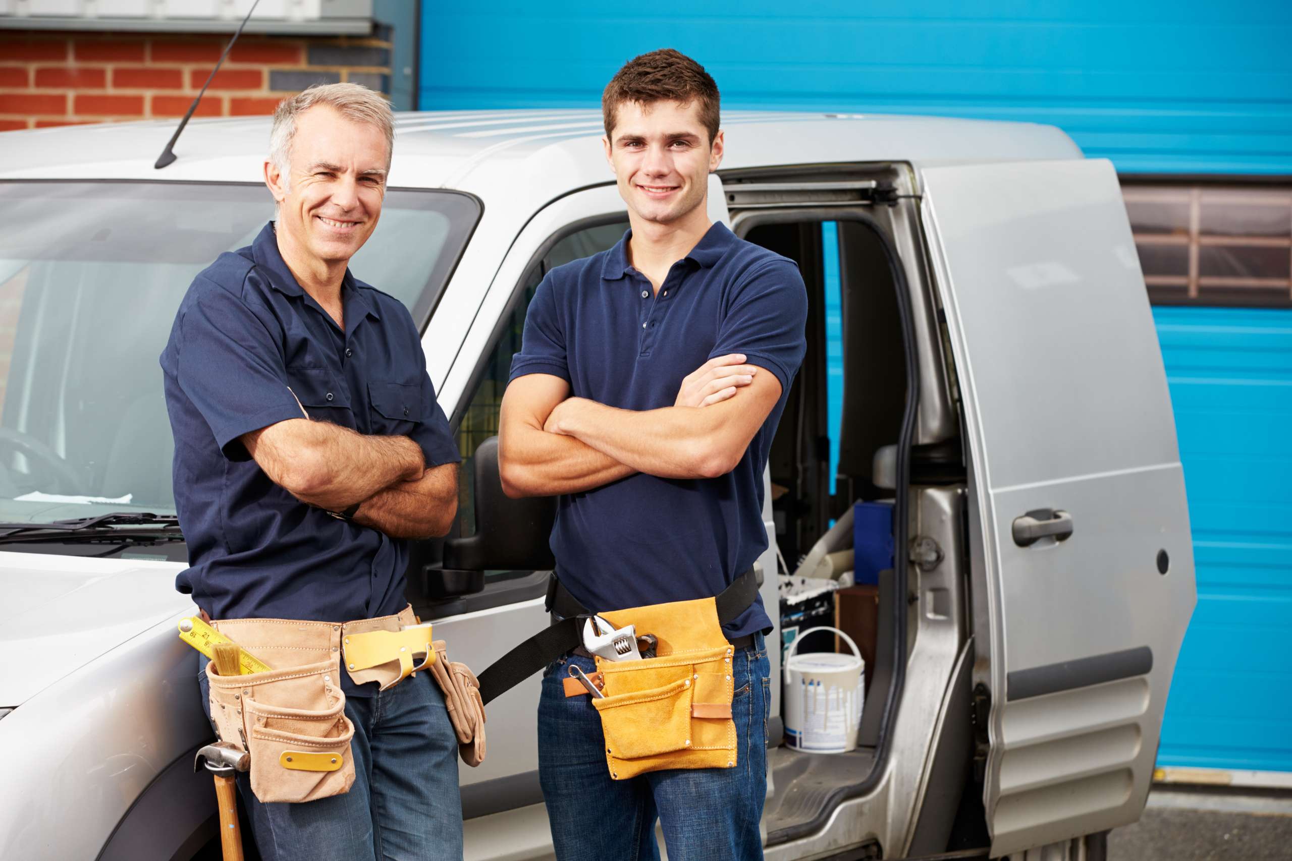 Two plumbers and construction workers with vehicle