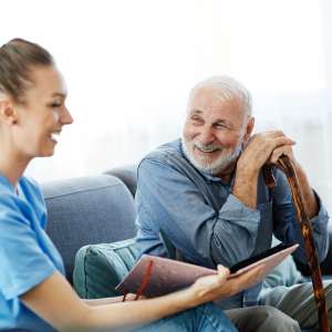 home health care worker assists senior man at home