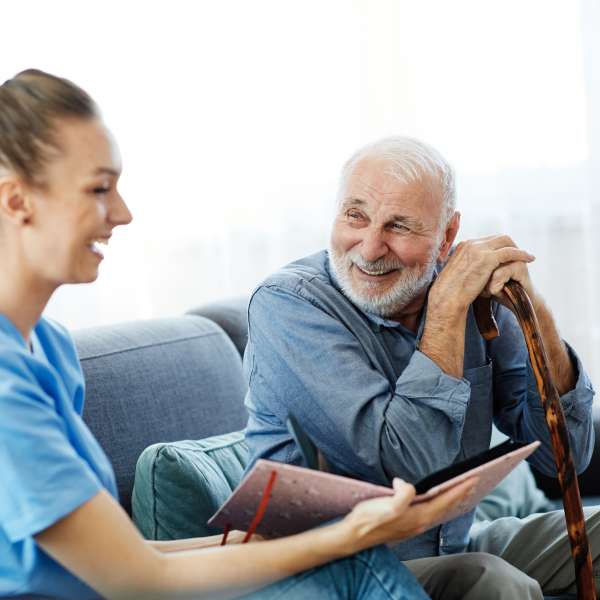 home health care worker assists senior man at home
