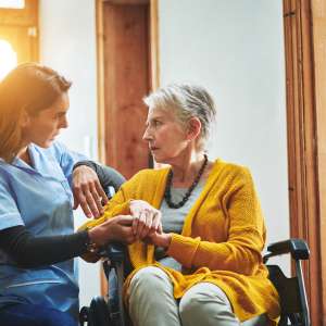 A young nurse with senior woman at home