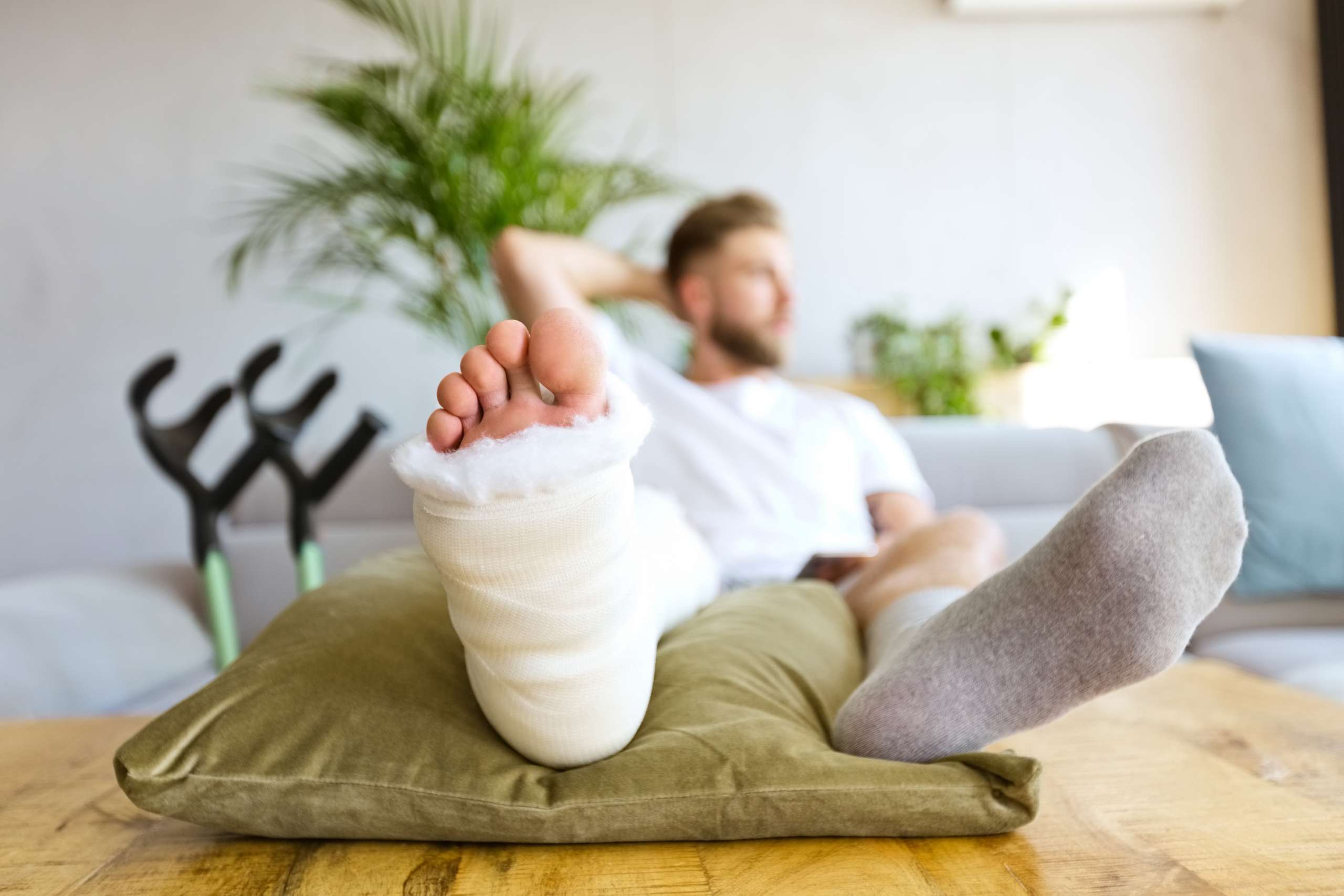 Young man with broken leg resting in bed