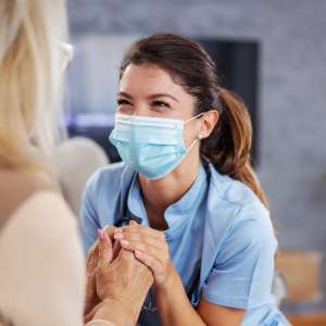 A nurse helps a senior woman.