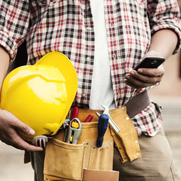 Contractor worker typing on a smartphone
