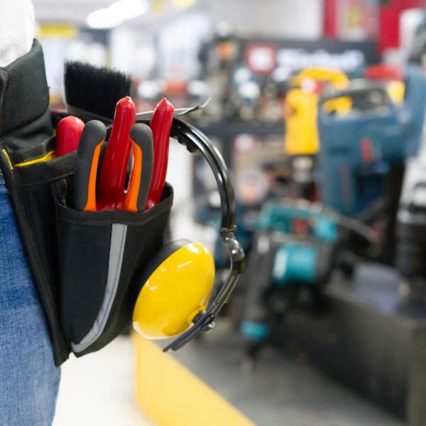 Handyman wearing a tool belt while shopping at the hardware store