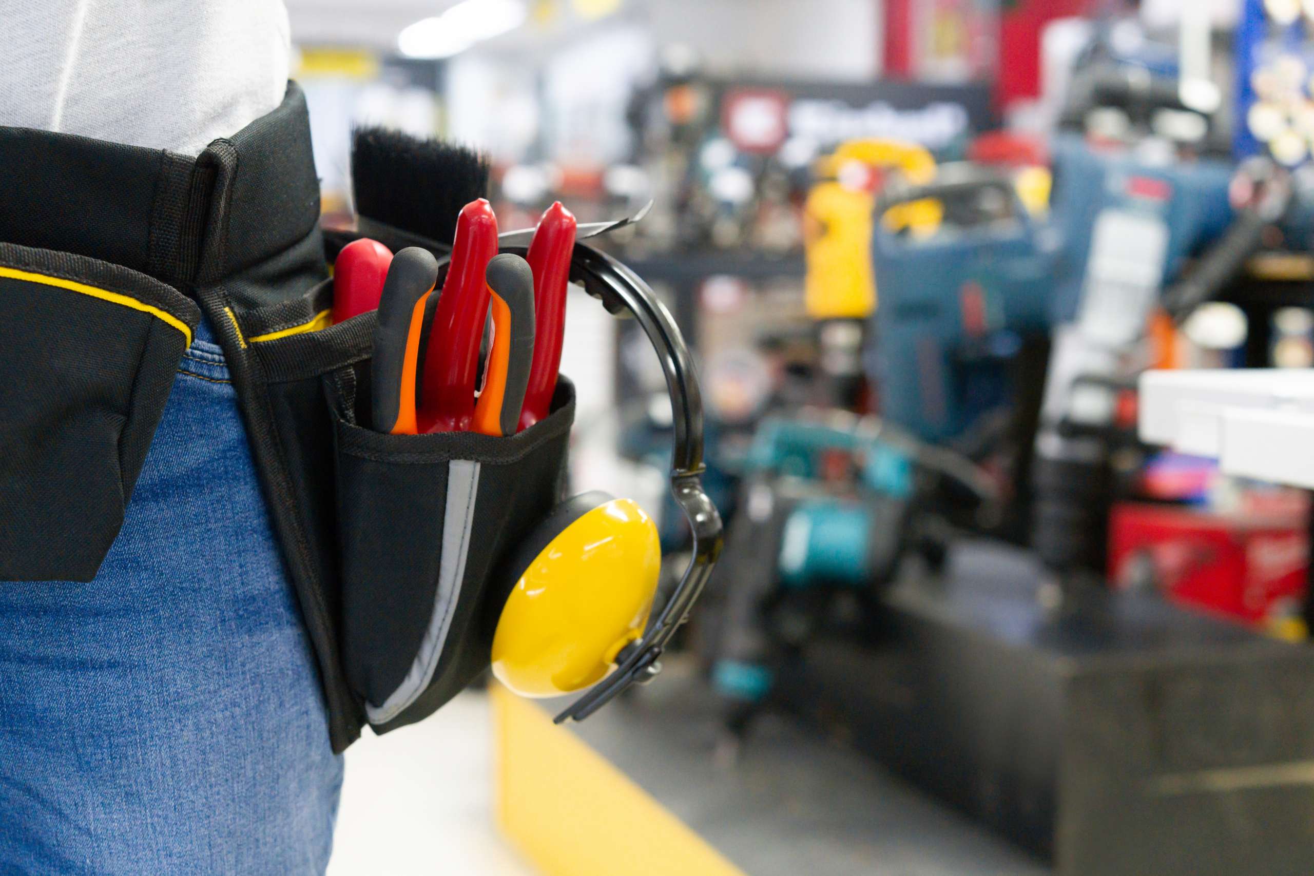 Handyman wearing a tool belt while shopping at the hardware store