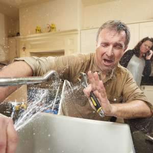 A plumber works with repairing the tap