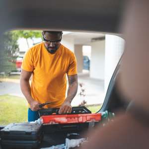 A electrician repairs a car