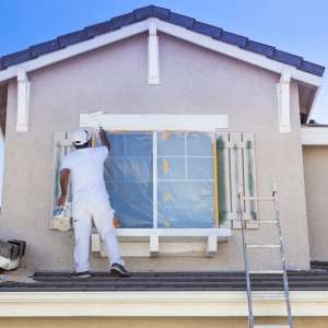 House Painter Painting the Trim And Shutters of Home