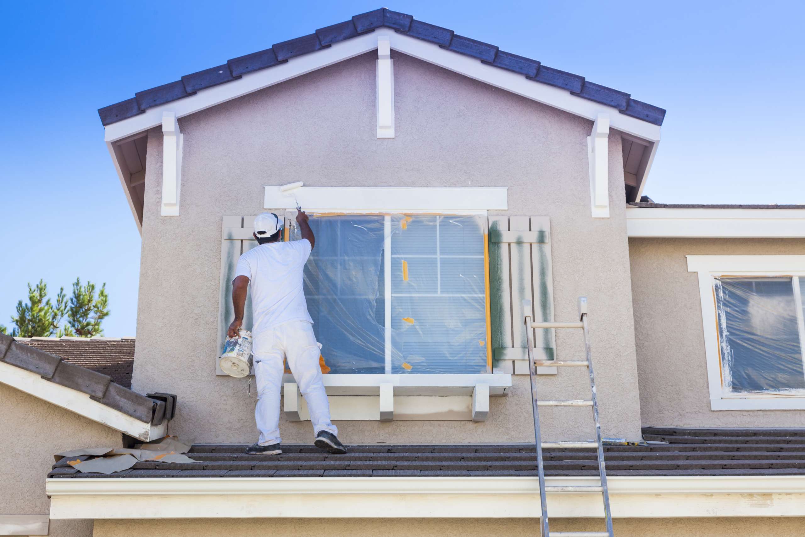 House Painter Painting the Trim And Shutters of Home