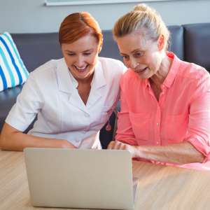 Nurse and senior woman using a laptop