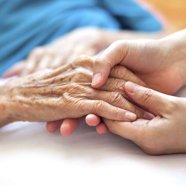 Helping the needy: Woman holding senior woman's hand
