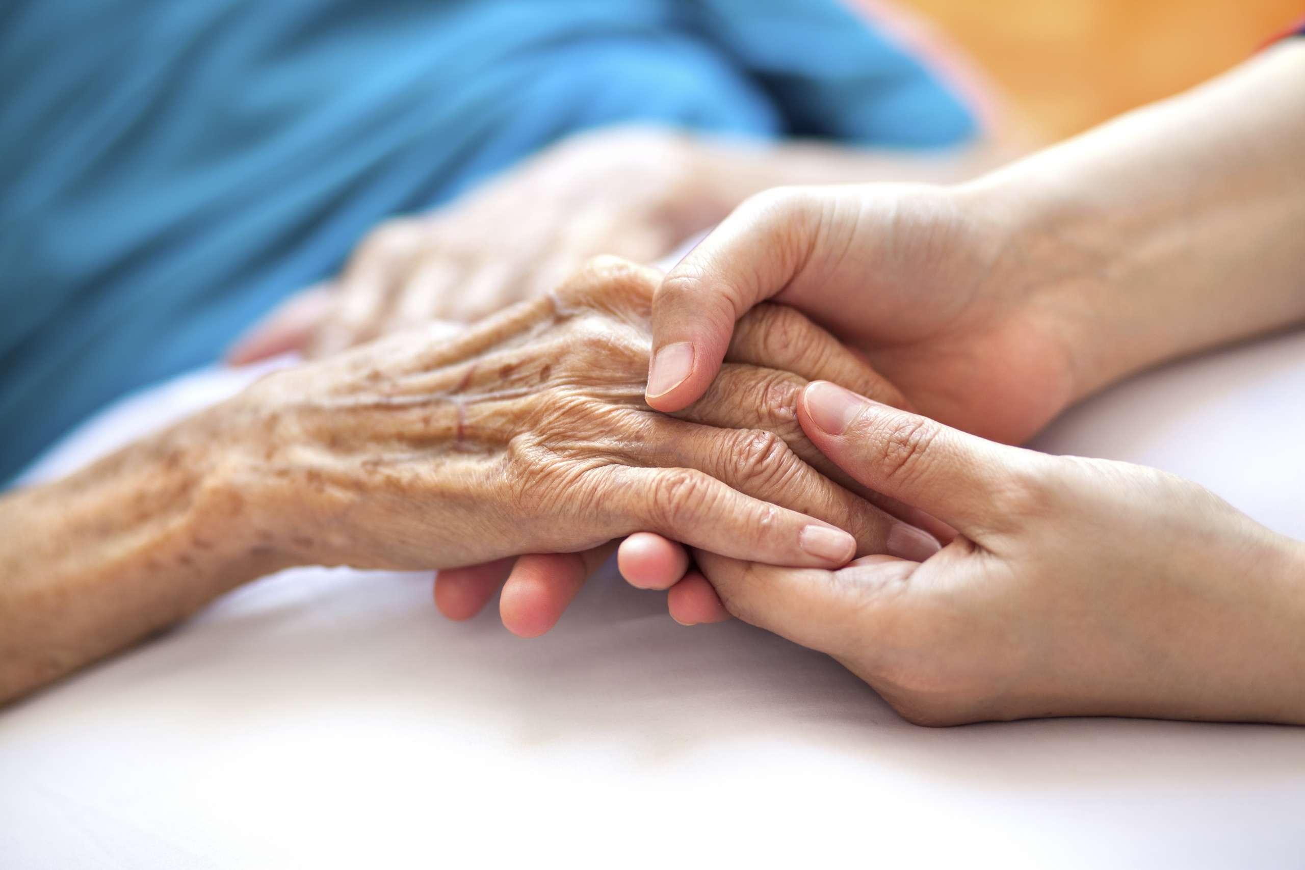 Helping the needy: Woman holding senior woman's hand