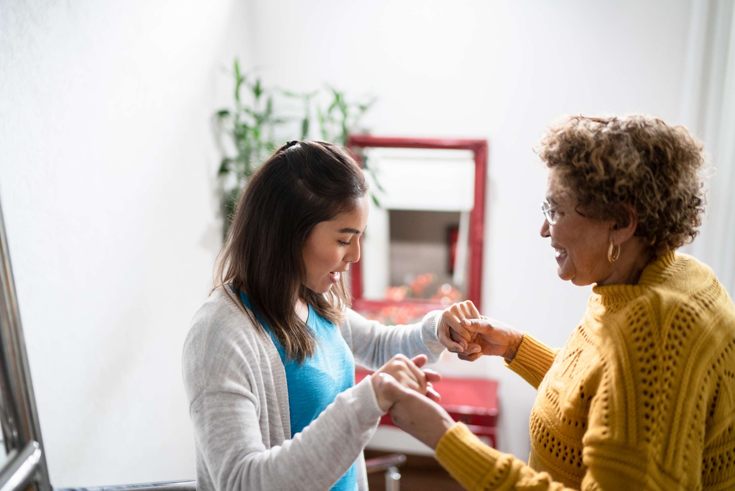 Nurse supporting senior patient walking the stairs at home