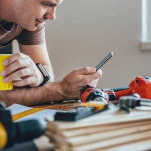 A handyman using smart phone for business