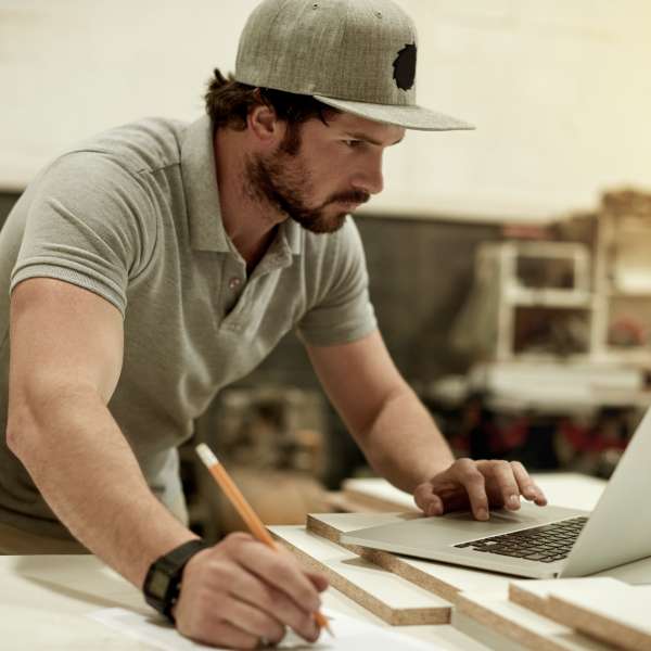 A handyman writes business planning in his workshop