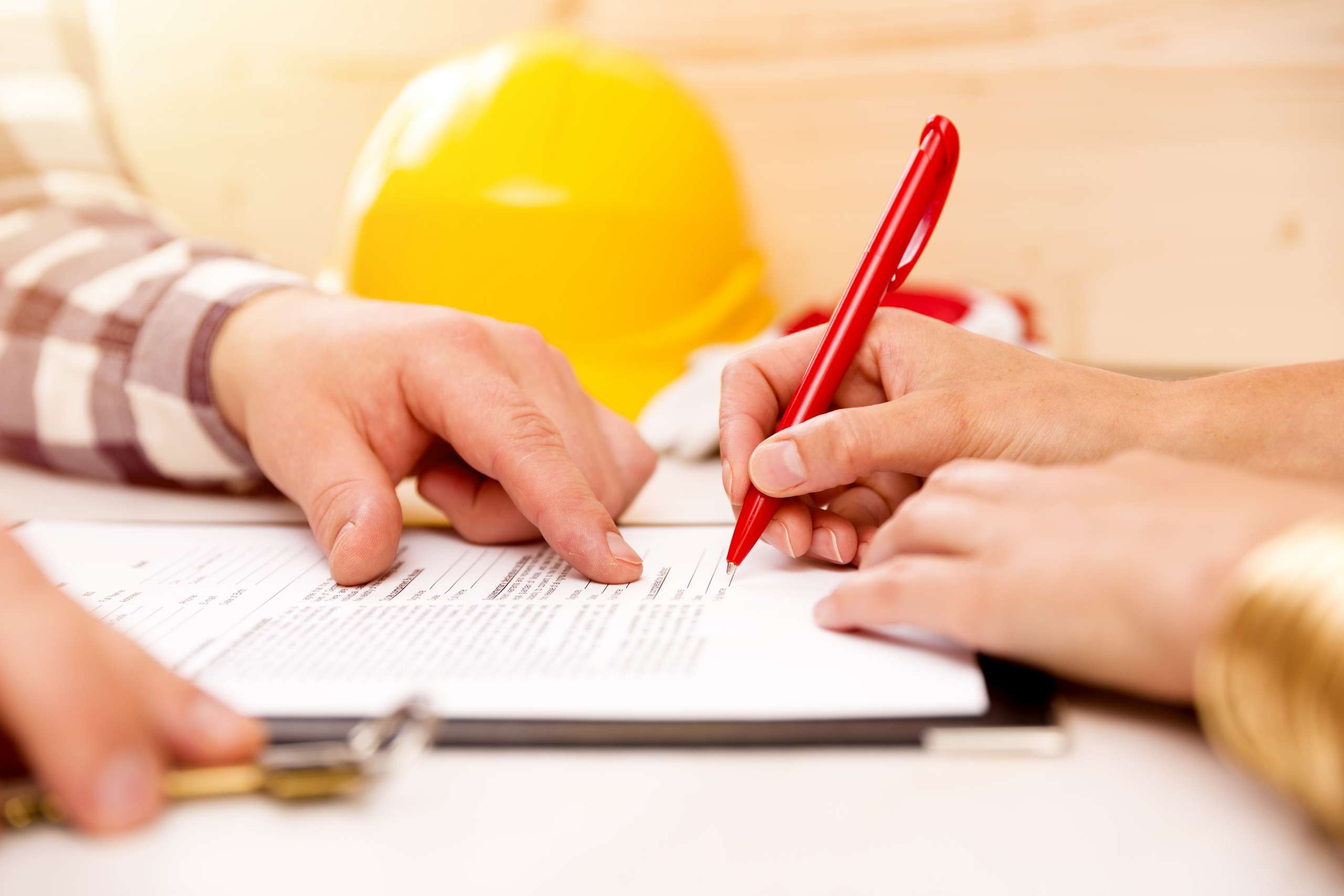 A handyman signing construction contract with contractor to build a house