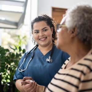 Home caregiver helping senior woman at home