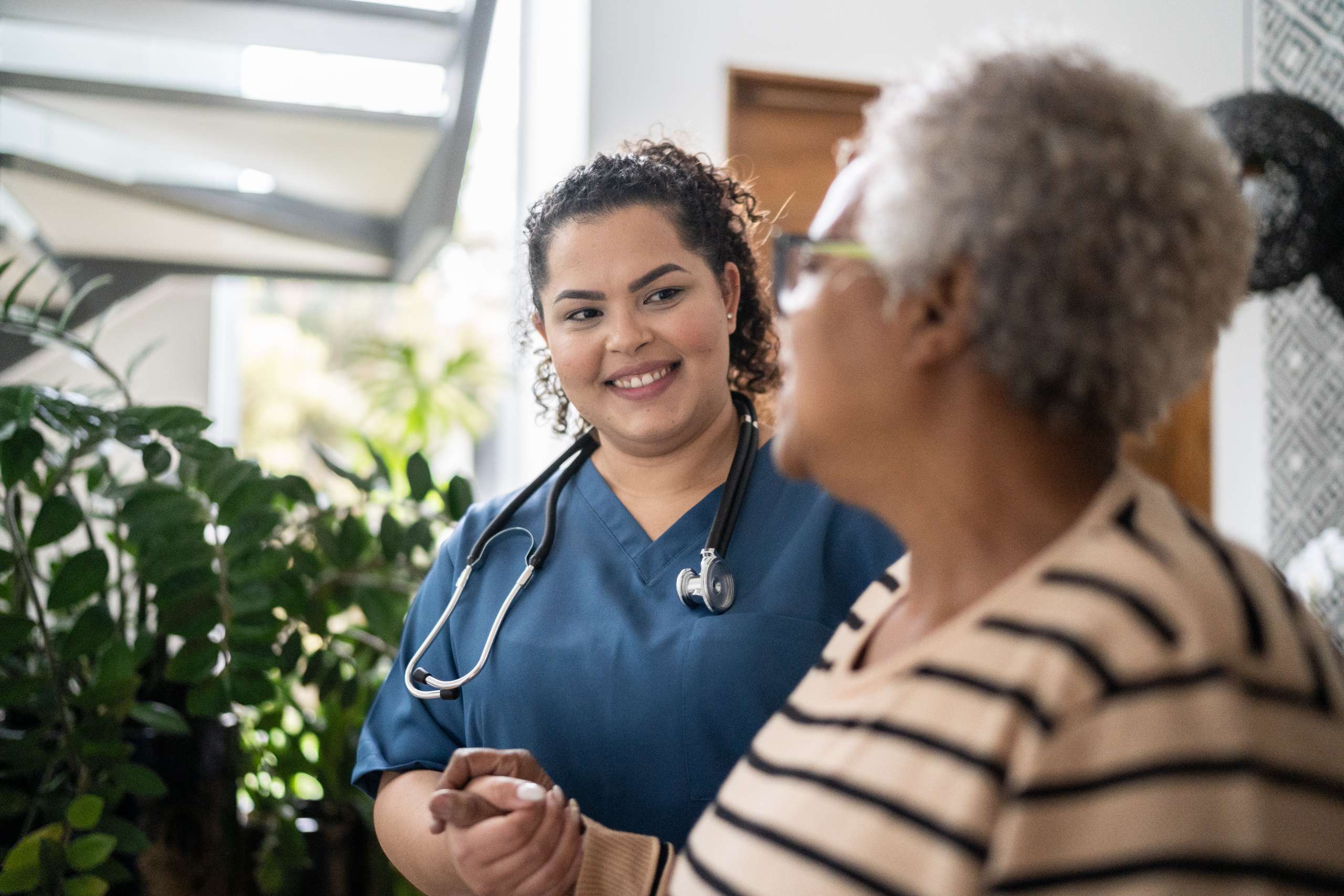 Home caregiver helping senior woman at home