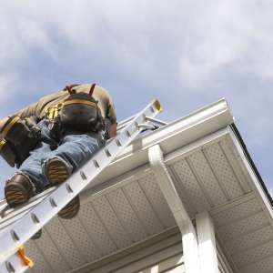 A Handyman goes up on ladder outdoors