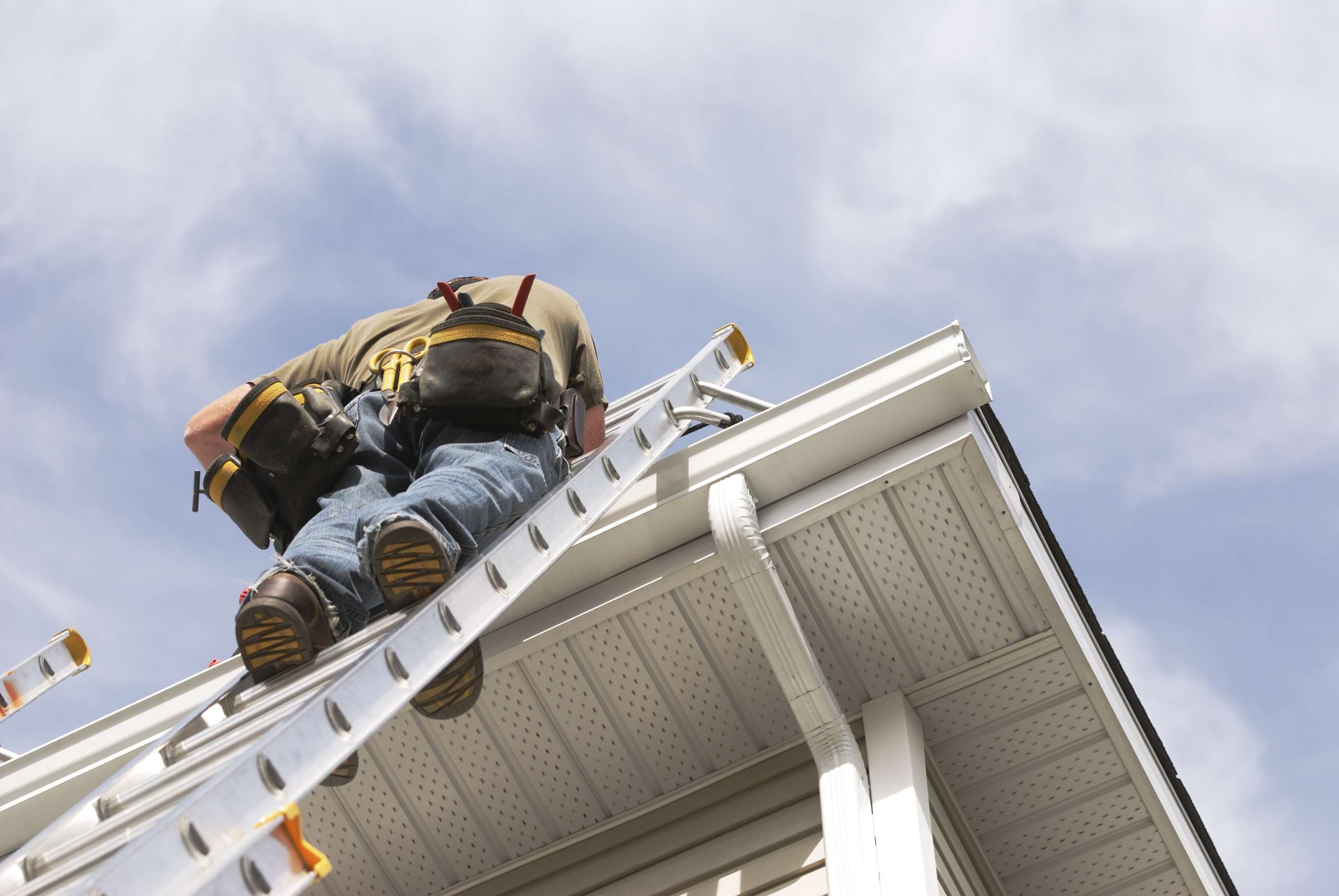 A Handyman goes up on ladder outdoors