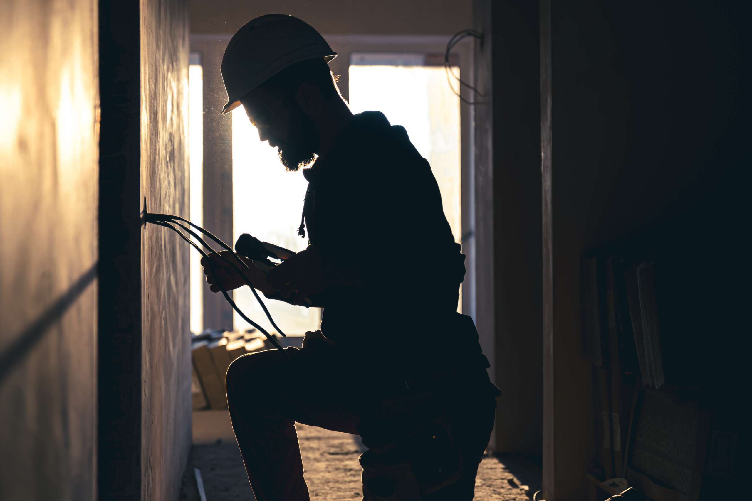 An electrician cuts wires with lineman's pliers.