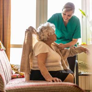 A Female nurse taking care of a senior woman at home