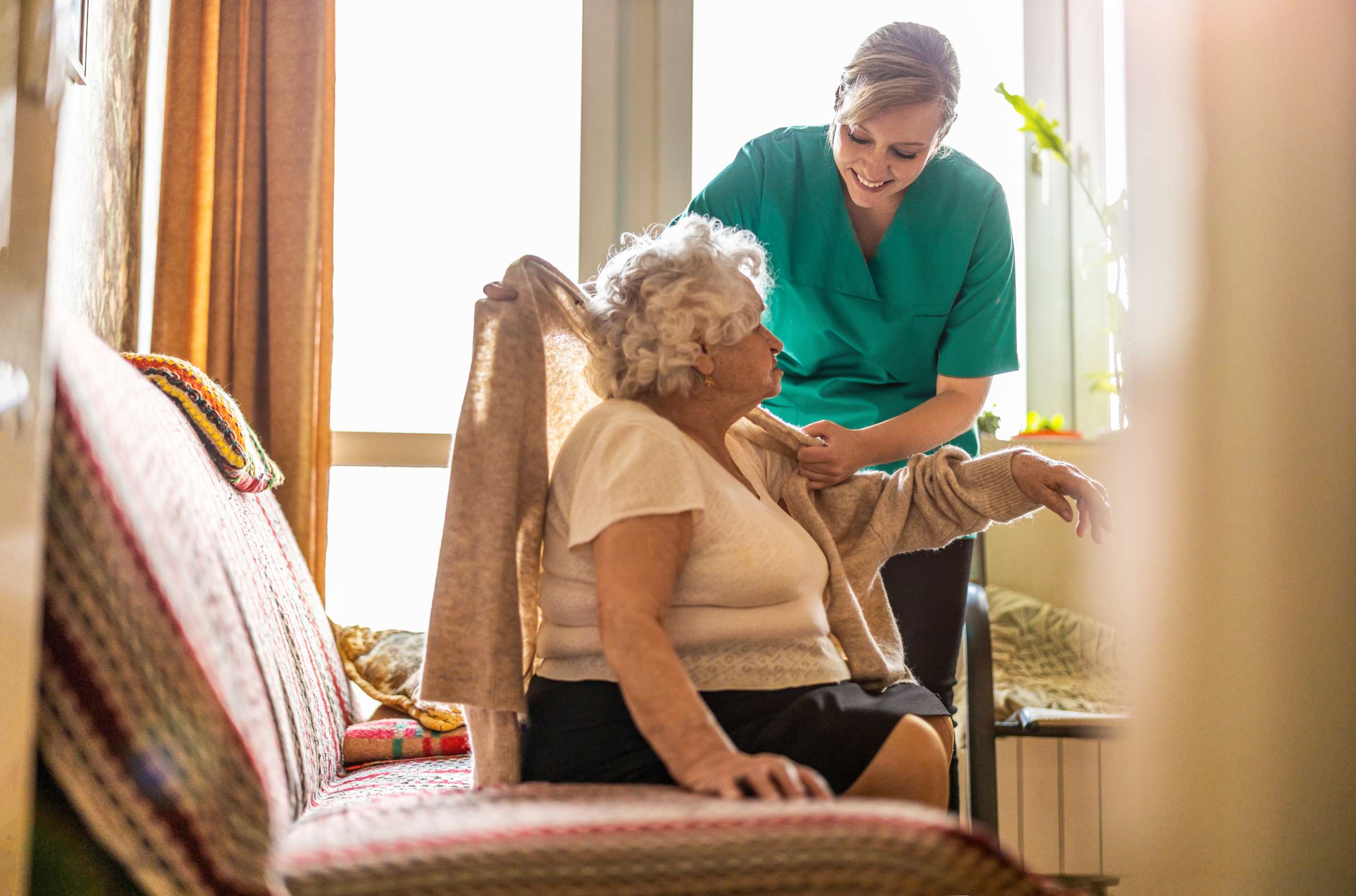 A Female nurse taking care of a senior woman at home